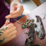 Maha Taitano links beads together by hand in her Santa Cruz studio. Photo by Devi Pride Photography